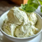 Cottage cheese mint ice cream in a white bowl topped with a fresh mint leaf