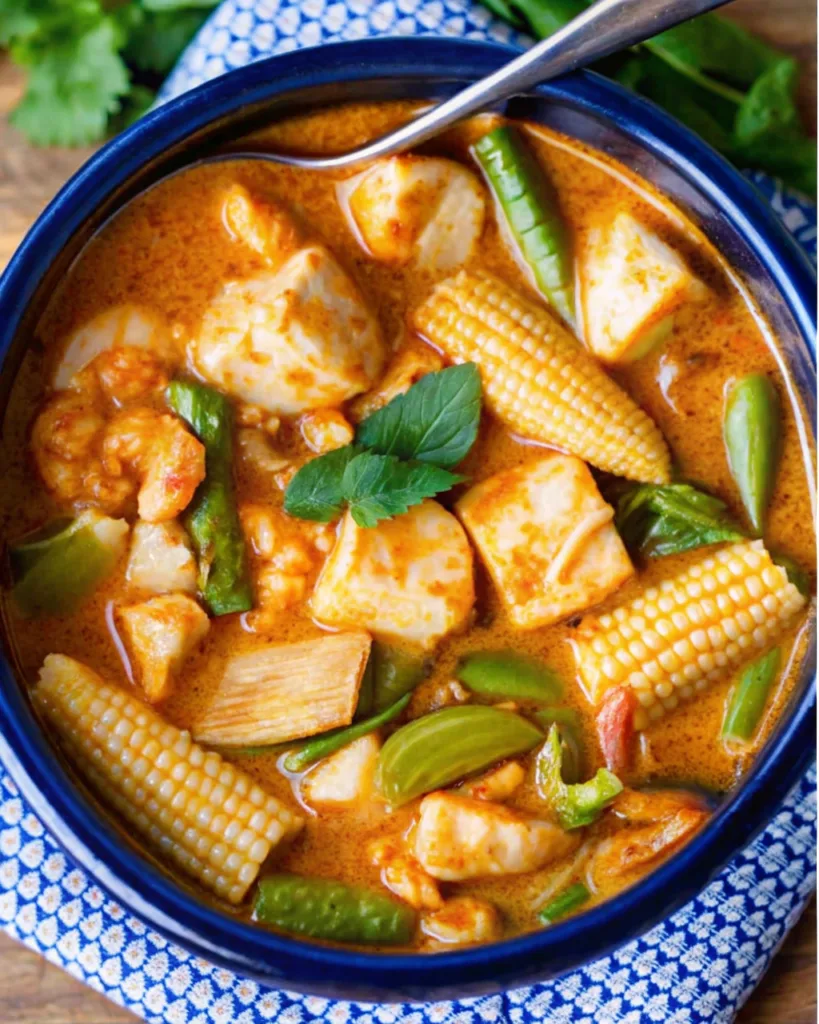 Red Thai Fish Curry with white fish, baby corn, and fresh green vegetables in a rich coconut milk red curry sauce.