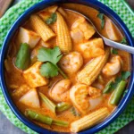 Red Thai Fish Curry with tender white fish, baby corn, and fresh vegetables simmered in a rich coconut milk red curry sauce.