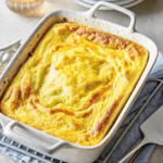 Fluffy microwave omelet baked in a white ceramic dish, golden and puffed on top.