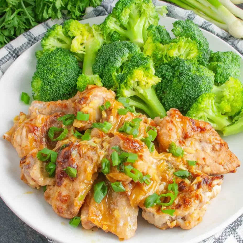 Keto Bang Bang Chicken with creamy sauce, topped with green onions and served with broccoli.